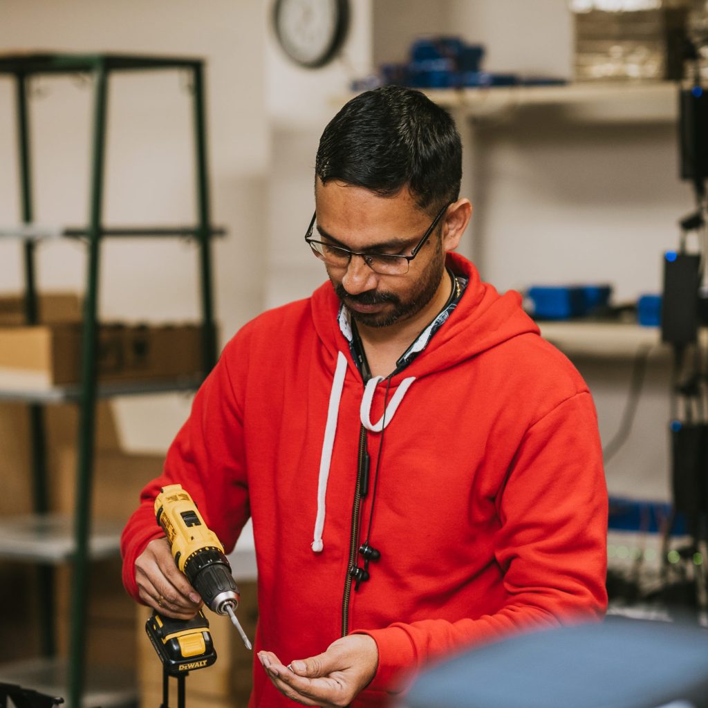 A worker standing with a power tool in their hand.